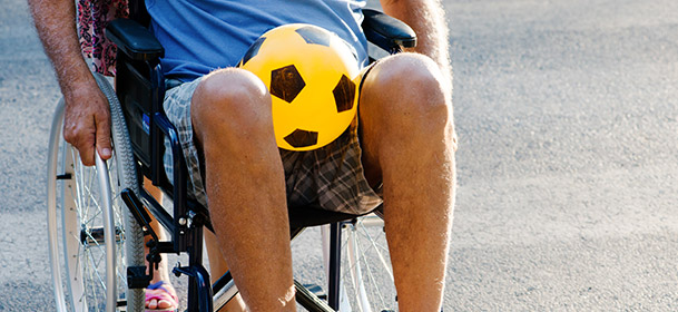 Man in wheel chair with soccer ball