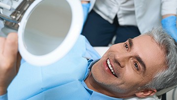 Older man smiling after receiving tooth-colored fillings 